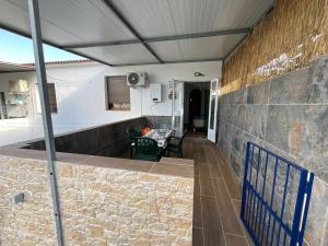 a patio with a stone wall and a table at Casa rural VTAR con piscina in Rosal de la Frontera