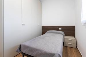 a small bedroom with a bed and a dresser at Romana Luxury Suite - SELF CHECK-IN WI-FI in Oleggio