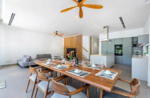 a dining room and kitchen with a large wooden table and chairs at Villa Hồ Tràm 4 Phòng Hồ bơi riêng cao cấp - Sanctuary Resort in Ho Tram