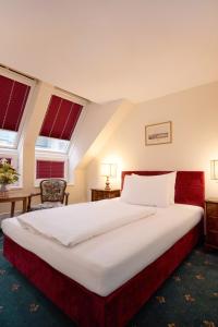 A bed or beds in a room at Graben Hotel
