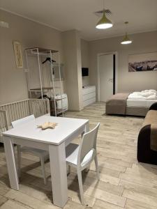 een witte tafel en stoelen in een kamer met een bed bij Appartamento con patio in Monopoli +4 foto's