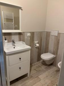 een badkamer met een witte wastafel en een toilet bij Appartamento con patio in Monopoli