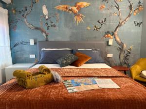 a bedroom with a bed with a bird mural at Al Sagraeto in Chioggia
