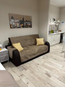 een bruine bank in een woonkamer met een keuken bij Appartamento con patio in Monopoli