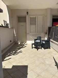 een patio met 2 stoelen en een tafel in een gebouw bij Appartamento con patio in Monopoli