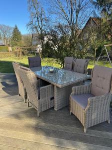a table and chairs on a wooden deck at Zur schönen Rosenblüte, Ferienhaus in Schülern