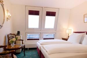 A bed or beds in a room at Graben Hotel