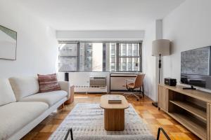 a living room with a couch and a table at Blueground Midtown East wd nr UN HQ NYC-1793 in New York