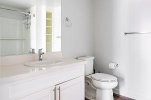 a white bathroom with a toilet and a sink at Blueground Downtown Berkeley AC nr UC Berkeley SFO-1824 in San Francisco +23 photos