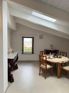 a dining room with a table and chairs and a window at Sea View Loft Meta Sorrento Coast Free Parking in Meta