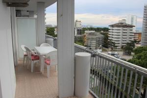 a balcony with a table and chairs and a view of a city at Duna 5i in Lignano Sabbiadoro
