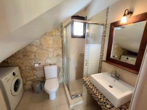 a bathroom with a toilet and a sink and a mirror at Artis Stone Heaven Retreat in Kalandra +11 photos