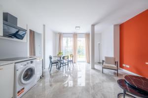 a living room with a washing machine and a table at Pine Living in Munich