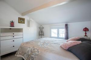 une chambre blanche avec un lit et une commode dans l'établissement Evasion Maritime, à Fréjus