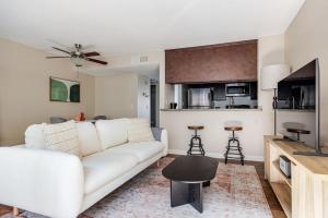 a living room with a white couch and a kitchen at Blueground Glendale pool AC nr Americana LAX-1319 in Glendale