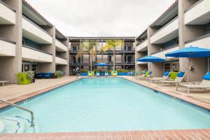 a large pool in a hotel with chairs and umbrellas at Blueground Glendale pool AC nr Americana LAX-1319 in Glendale