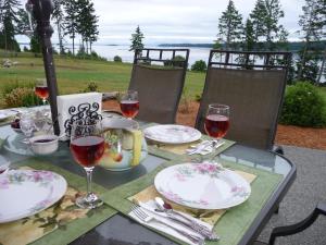 a table with glasses of wine and plates on it at Two Eagles Lodge in Union Bay
