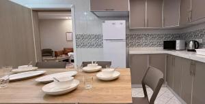 a kitchen with a table with white dishes on it at شقق السماح الفاخرة in Taif +16 photos