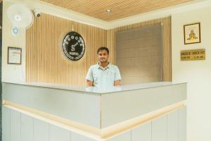 a man standing behind the counter of a restaurant at HOTEL SNOOZE in Jaipur