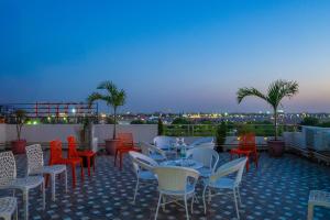 a patio with tables and chairs on a roof at HOTEL SNOOZE in Jaipur