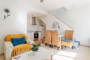 Una sala de estar con un sofá y sillas y una mesa. en Ballesteros, en Santa Pola