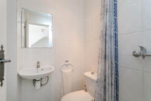 Un baño con lavabo, inodoro y espejo. en Ballesteros, en Santa Pola 16 fotos más