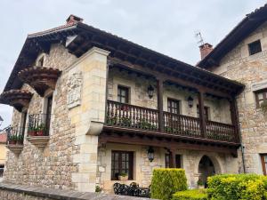 a large stone building with a balcony on it at Apartamentos Villa Julieta in Ruente