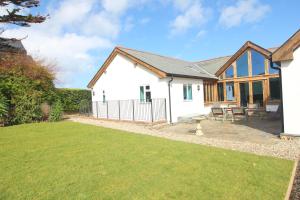 ein Cottage mit einer Liegewiese davor in der Unterkunft Beachside holiday home in Saint Merryn