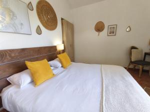 菲加里艾苏拉贝拉旅馆的一间卧室配有白色床和黄色枕头