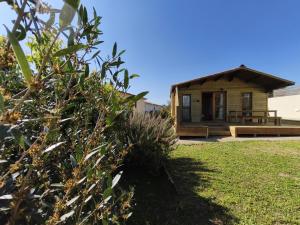 una piccola cabina di legno con un cortile erboso di Chambres Isula Bella a Figari