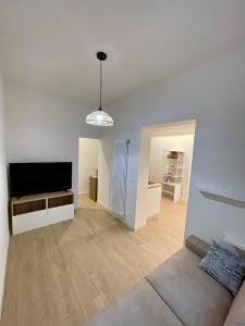an empty living room with a flat screen tv at Deluxe Apartment a 2 passi dal mare - FIERA GENOVA in Genova