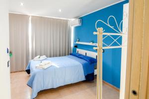 a blue bedroom with a bed and a blue wall at La Casetta sul Mare in Isola delle Femmine