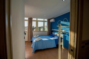 a blue bedroom with a bed and a window at La Casetta sul Mare in Isola delle Femmine