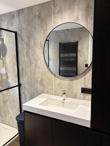 a bathroom with a white sink and a mirror at 't Holten Huus - Puur genieten in het bos. in Norg +48 photos