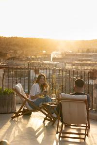 a man and a woman sitting in chairs on a balcony at Paradise Cappadocia Hotel in Goreme