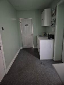 a kitchen with a white door and a white refrigerator at ACCOMADATION WREXHAM in Wrexham