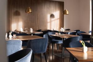 a dining room with wooden tables and blue chairs at ElzLand Hotel Pfauen WELLNESS & SPA in Elzach