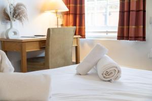 Una habitación de hotel con una cama con toallas. en The Red Lion Hotel, en Spalding