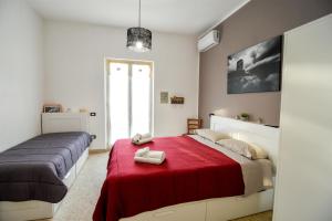 a bedroom with two beds and a red blanket at La Casetta sul Mare in Isola delle Femmine