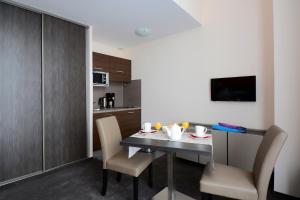 a dining room with a table and chairs in a kitchen at Odalys City Montpellier Les Occitanes in Montpellier