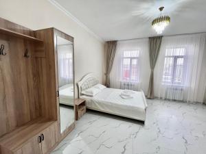 a large room with two beds and a mirror at New hotel BEKARYS in Astana