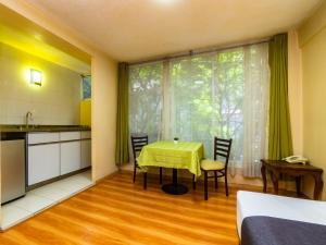 a room with a table and chairs and a kitchen at Capital O Hotel Suites Marne, Mexico City in Mexico City