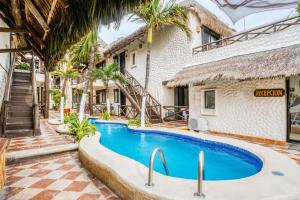 a swimming pool in front of a building at Capital O Mimi Del Mar, Playa del Carmen in Playa del Carmen