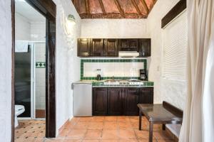 a kitchen with wooden cabinets and a sink at Capital O Mimi Del Mar, Playa del Carmen in Playa del Carmen