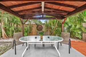 a table and chairs on a patio with a wooden ceiling at Hollywood Beach & Casino Heated Pool House in Hollywood