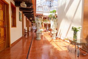a hallway with vases and tables in a building at Capital O Hospedaje Los Angeles San Cristobal De Las Casas in San Cristóbal de Las Casas