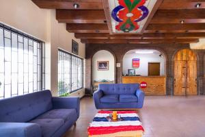 ein Wohnzimmer mit zwei blauen Sofas und einem Tisch in der Unterkunft OYO Hotel Real Del Sur, Estadio Chihuahua in Chihuahua