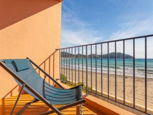 una silla azul sentada en un balcón con vistas a la playa en Apartment Baie des Lecques by Interhome, en Saint-Cyr-sur-Mer