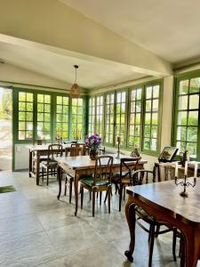 a dining room with tables and chairs and windows at Hotel Le Ponteil in Antibes