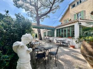 a statue of a horse next to a table and chairs at Hotel Le Ponteil in Antibes